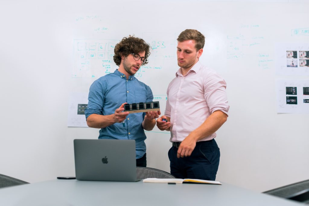 A picture of two professionals looking at a piece of hardware as this article is about improving SD-WAN security. SD-WAN architectures are on the rise but what additional security tools or coverage is necessary.